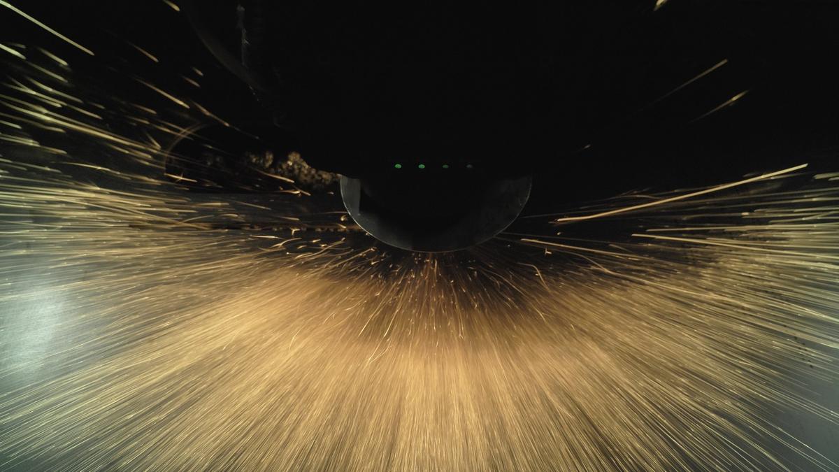 Sparks spraying out beneath a fiber laser cutting head